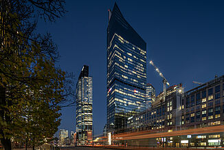 Illuminated office and commercial buildings with the Skyliner Tower in Warsaw at night.
