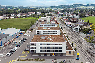 Aerial view of a mixed-use building with flats above a Lidl supermarket.