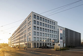 Corner view of the Seetor City Campus in Nuremberg with tram lines in front of the building.