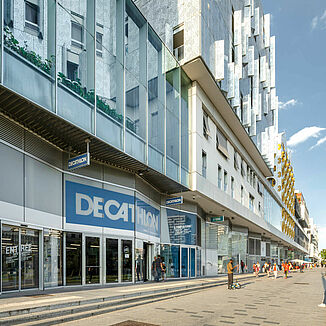 Façade of a mixed-use building complex in Paris, in which the Decathlon sports shop is located on the ground floor.