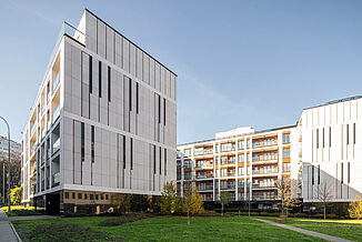 Piano House residential building in Warsaw with green inner courtyard and benches.