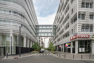 Two parts of the Conseil Régional of the Île de France region in Paris, connected on the upper floors by a glass overpass.