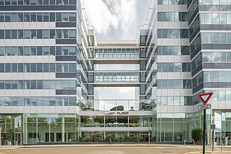Entrance area of the mixed-use building West Plaza with glass façade.