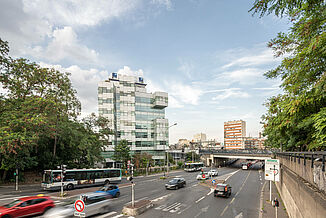 A busy street in Paris with a BRED Bank office complex in the background.