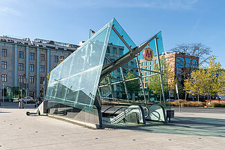 Metro entrance with escalator and glass roof in Warsaw.