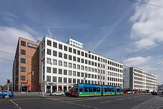 View of the Seetor City Campus urban quarter in Nuremberg with a tram in front of the building.