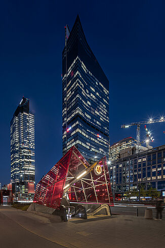Night view of the Warsaw Skyliner Tower with metro station in the immediate vicinity.