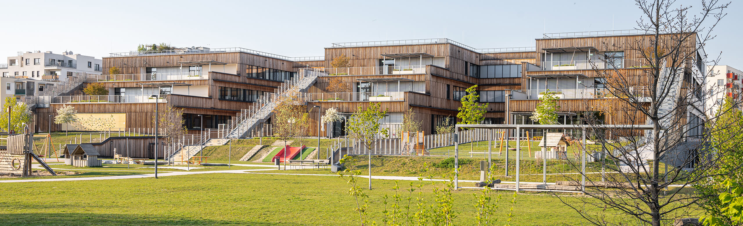 Exterior view with various terraces of the Seestadt Aspern educational campus in Vienna.