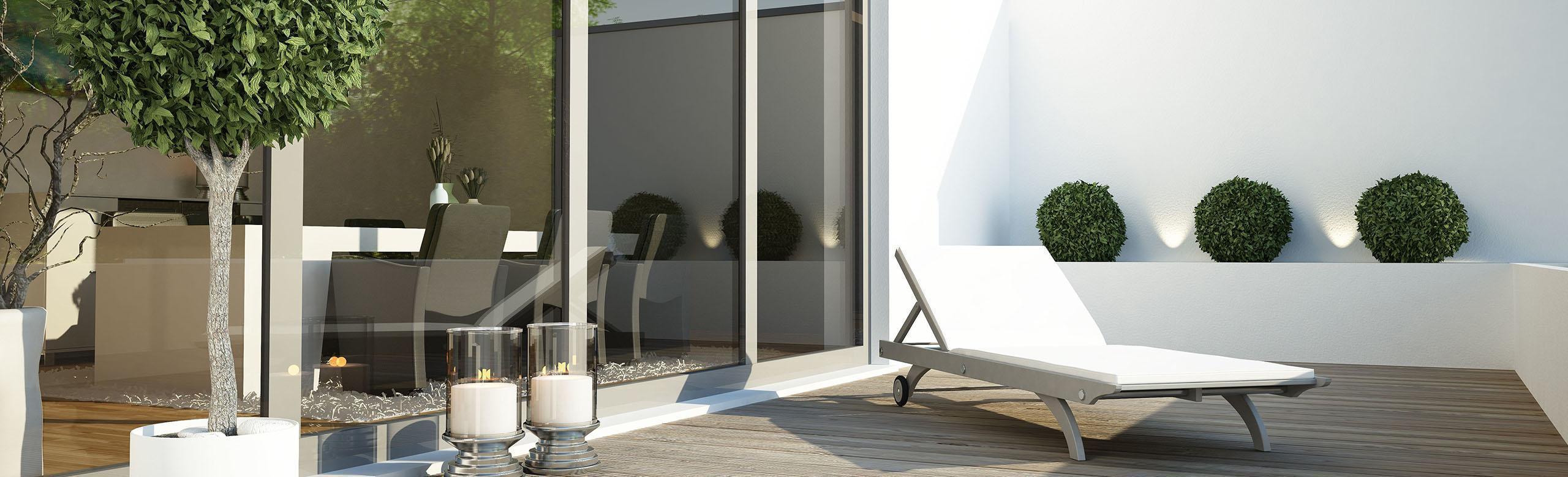 Modern roof terrace with a wooden floor construction on which there is a lounger.