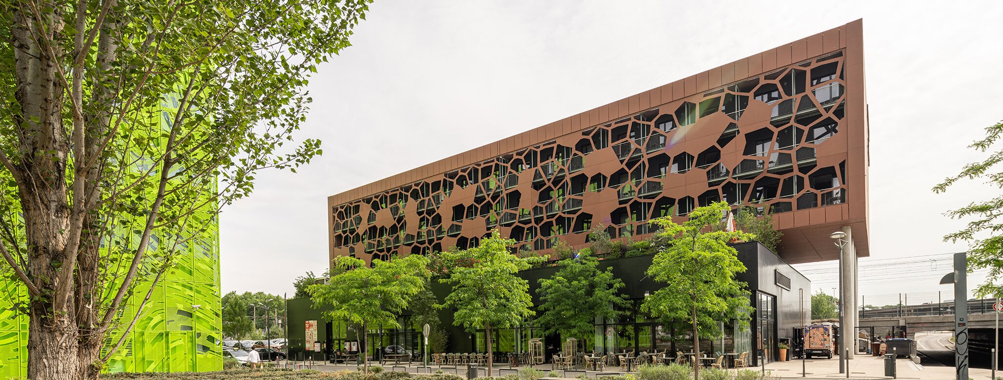 Exterior view of the modern MOB Hotel in Lyon with outdoor seating areas.